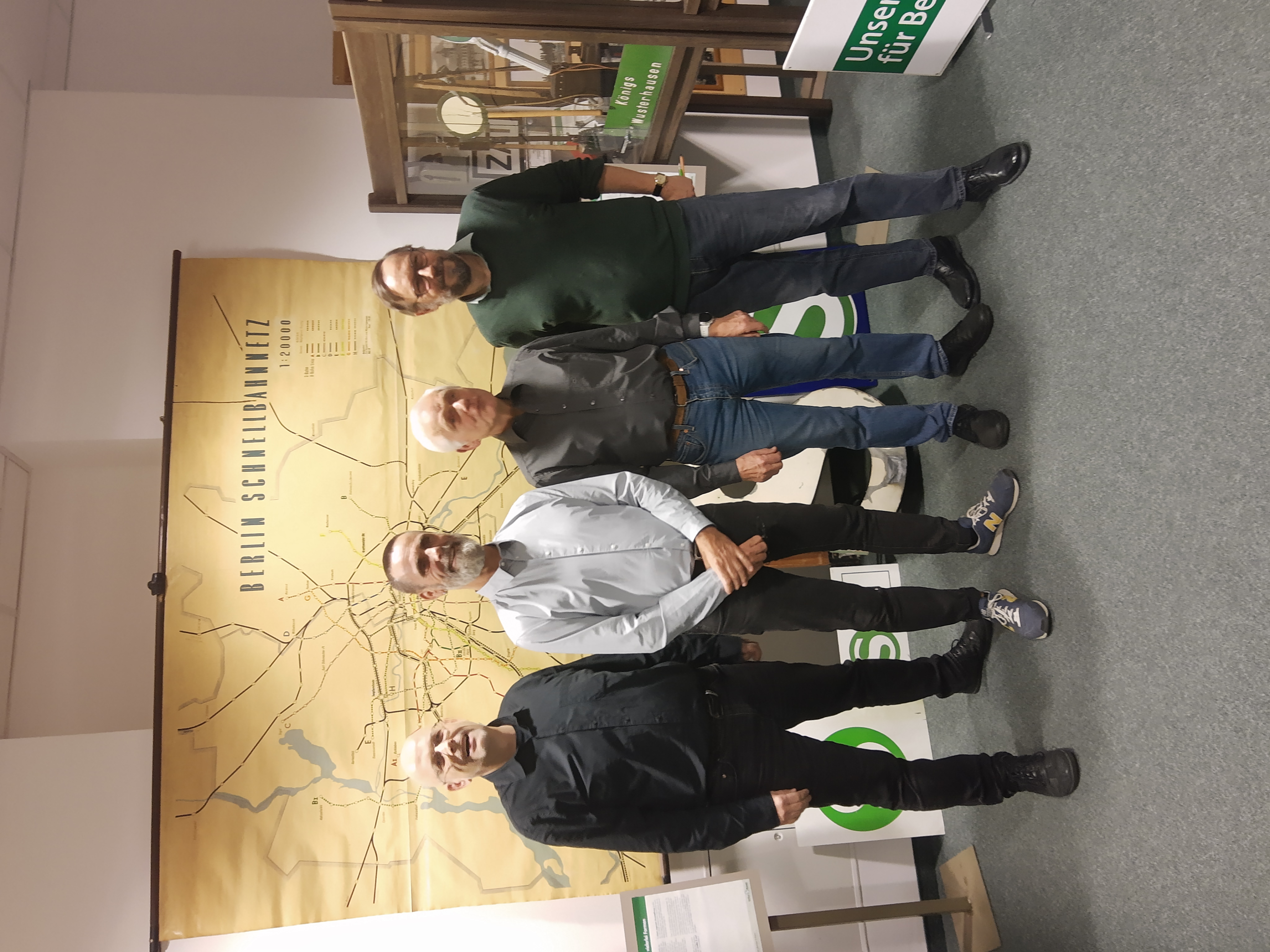 Die vier Referenten stehn vor einem Berlin-Plan